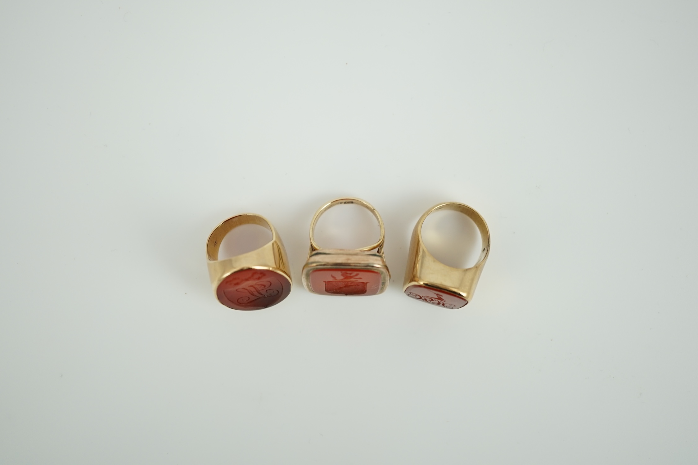 A Victorian 9ct and carnelian set intaglio ring, carved with a crest size L and two other similar yellow metal and carnelian intaglio ring, gross weight 35.8 grams.